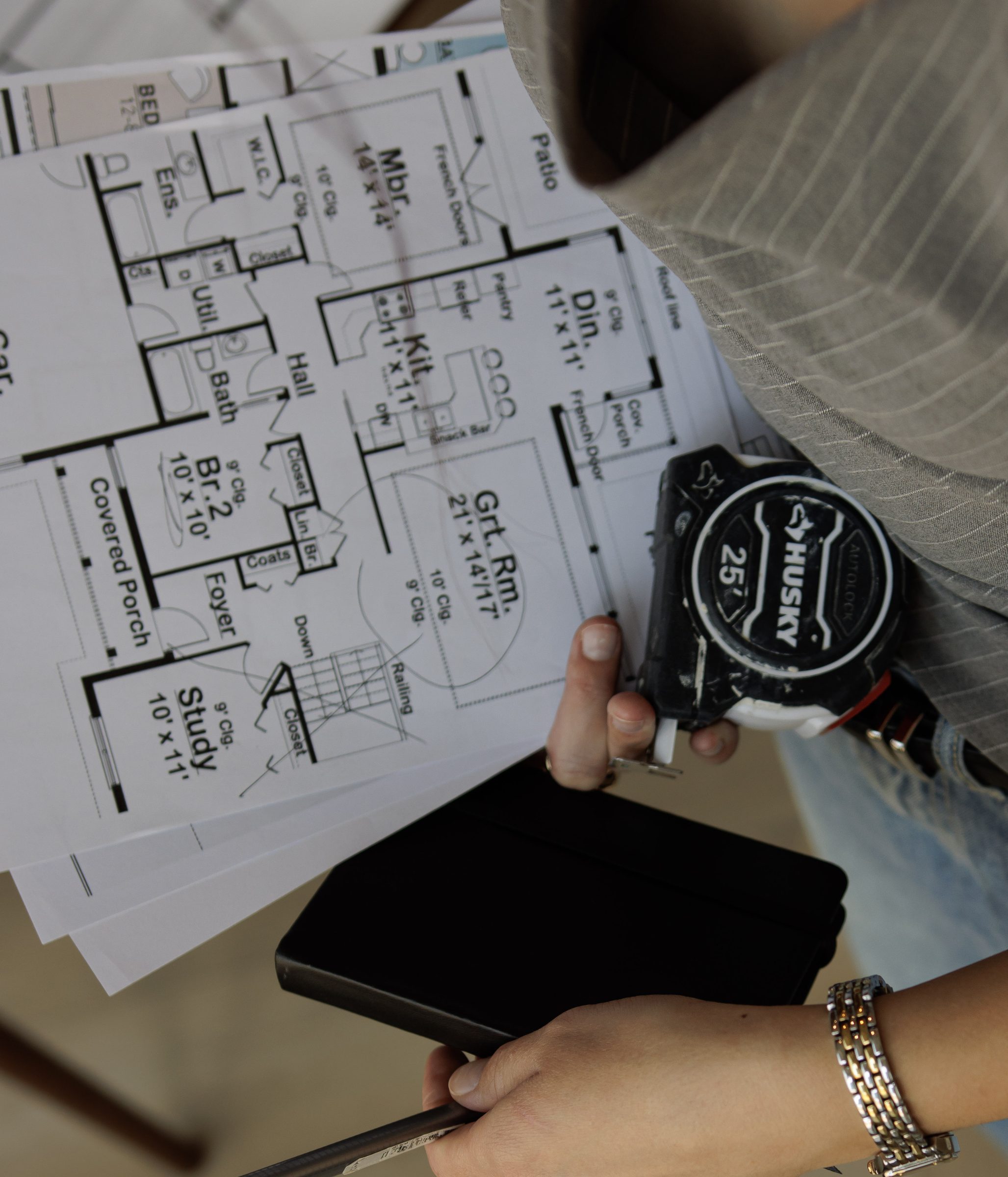 Holding a floor plan, tape measure and notebook